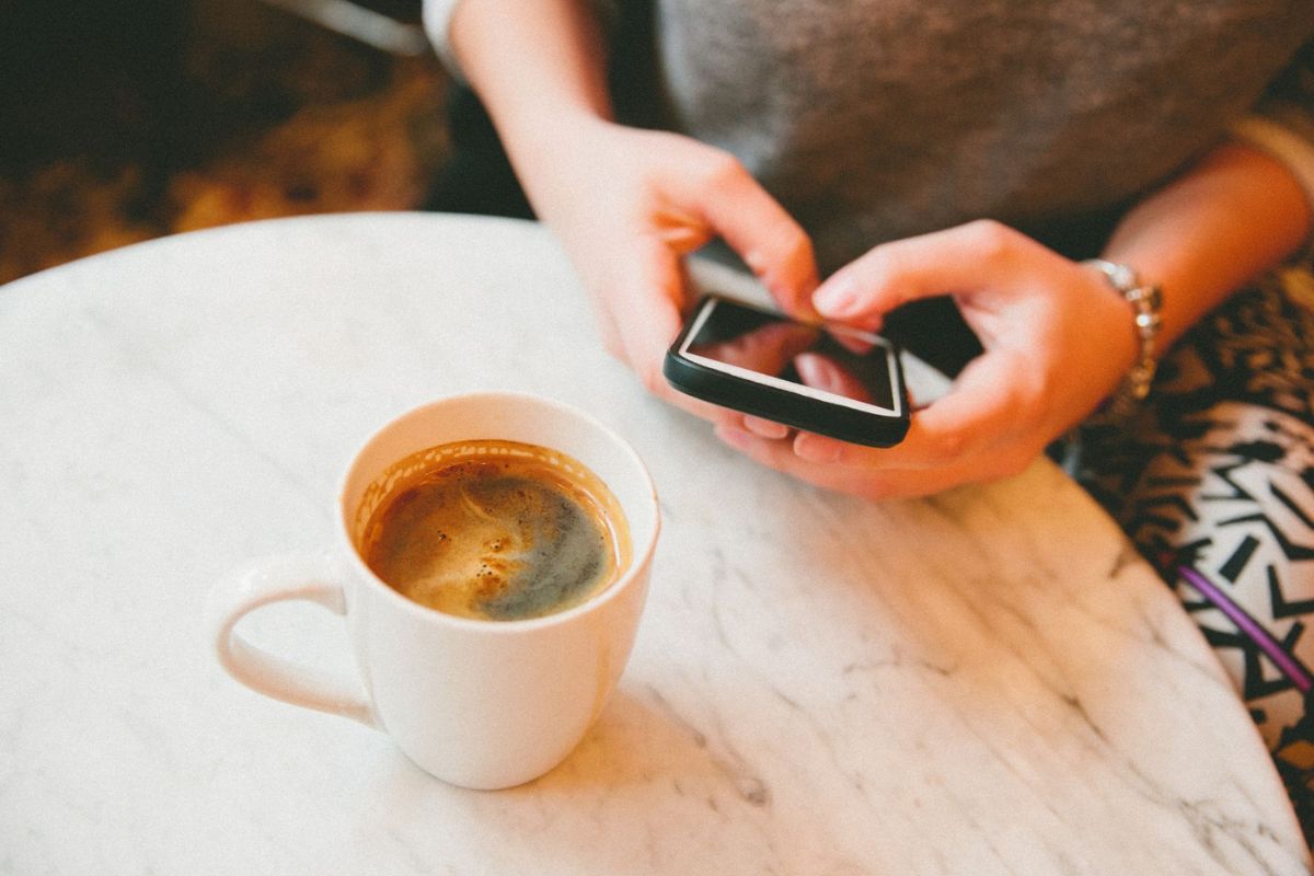 Person checking their phone in a coffee shop